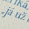 Detail kaligrafie na ručním papíru. Písmo antikva psaná špičatým perem.